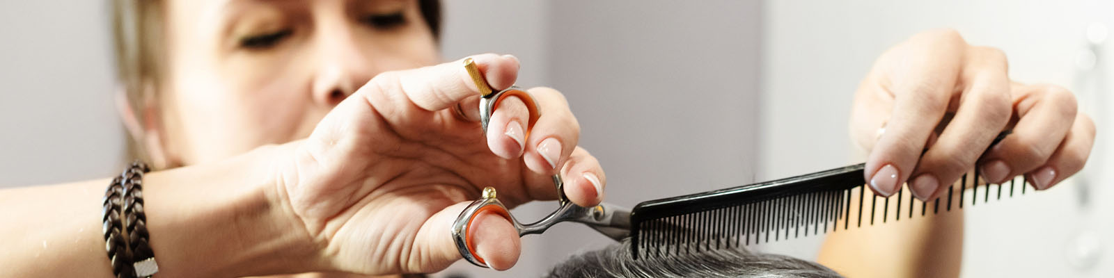 A woman cutting a senior man's hair