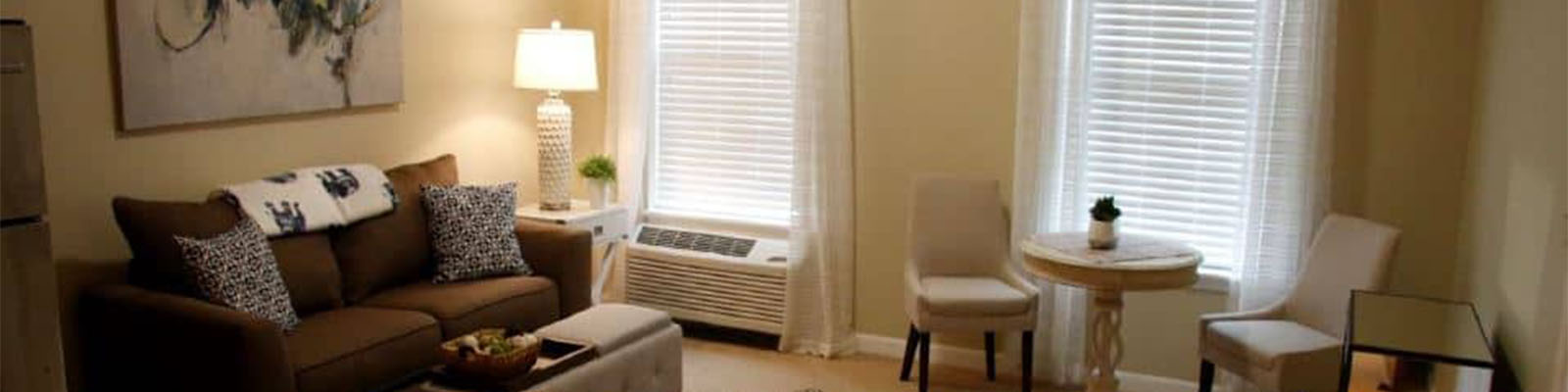 A living room with the lamp turned on in a senior living apartment